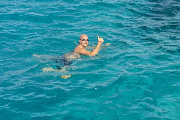 man with snorkel mask tuba and snorkel in sea. Snorkeling, swimming, vacation. Tourists are engaged in snorkeling in the open sea. Holidays in the seaside resort