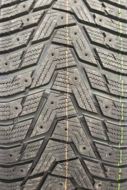 Yakın çekim kış lastiği basmak. Dokulu lastik sırt. Yepyeni modern kış araba lastik parçası. dikey fotoğraf