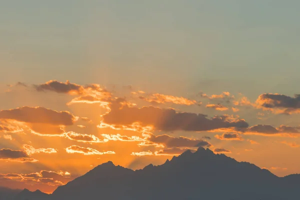 O pôr-do-sol atinge o céu. Montanha picos vista do pôr-do-sol. Montanha pôr do sol céu nuvens — Fotografia de Stock