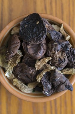 eski bir ahşap zemin üzerinde bir plaka üzerinde kurutulmuş mantar çörek dilimlenmiş. Kurutulmuş mantar ve plaka üzerinde ahşap arka plan kompozisyonu. dikey fotoğraf