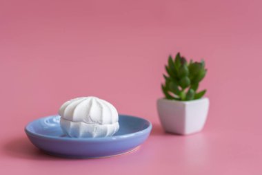 Mavi plaka pembe bir arka plan üzerinde beyaz pasta