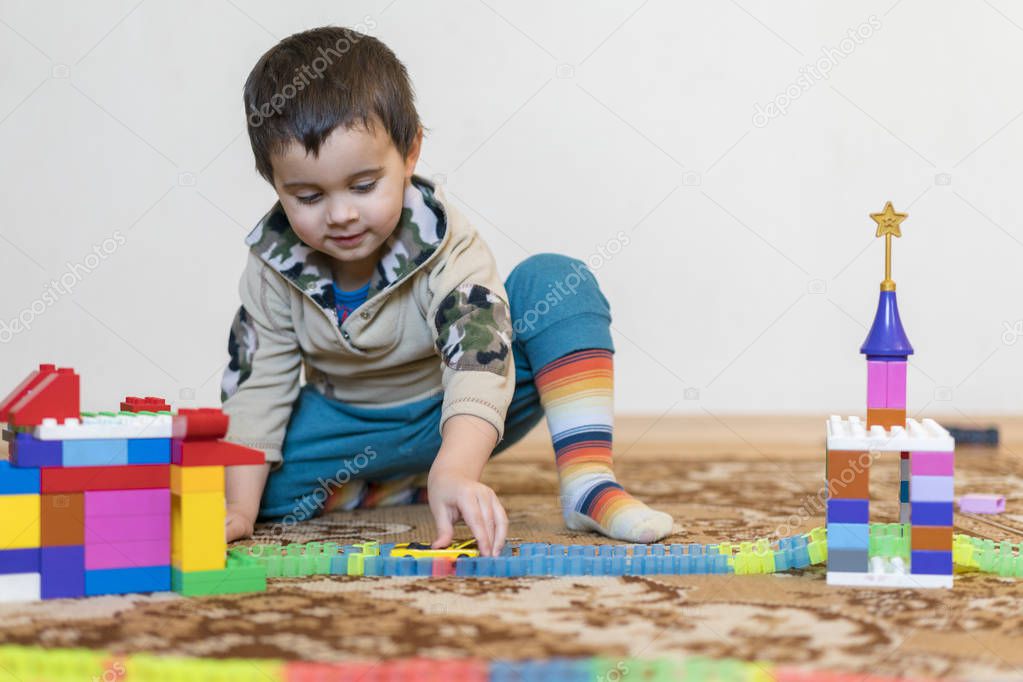 little smiling boy playing with constructor toy. Boy playing intellectual toys