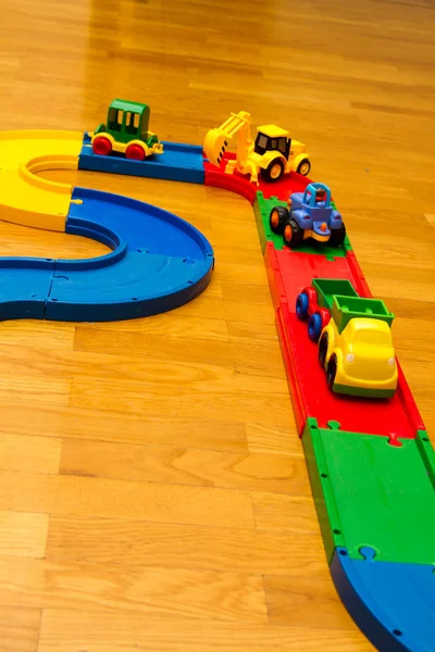 Juguetes infantiles en el suelo de la habitación. Camino de máquina — Foto de Stock