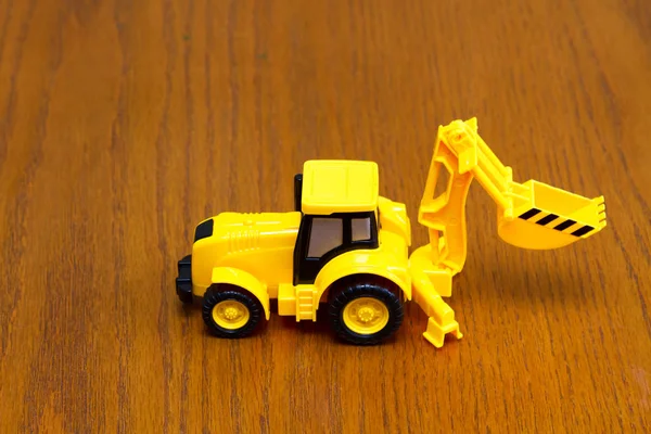 Tractor infantil amarillo sobre fondo marrón — Foto de Stock