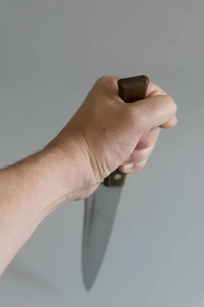 Mano de hombre con un cuchillo sobre fondo gris. Concepto de violencia. Mano de gángster con cuchillo. espacio de copia. foto ertica — Foto de Stock