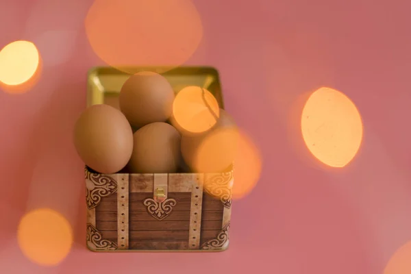 Пасхальные яйца в груди на розовом фоне. bokeh — стоковое фото