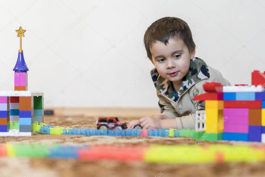 little smiling boy playing with constructor toy. Boy playing intellectual toys
