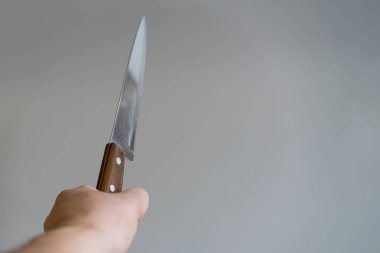 Elini gri arka plan üzerinde bir bıçakla. Şiddet kavramı. El ile bir bıçak bir gangster.