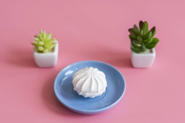 Mavi plaka pembe bir arka plan üzerinde beyaz pasta.