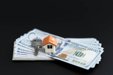 Küçük Model ev ve yeni tasarlanmış Amerikan tuşları Yüz dolarlık banknotlar. Satın alınan evin anahtarları. Siyah bir arka plan şirketten indirimli kopyasını.