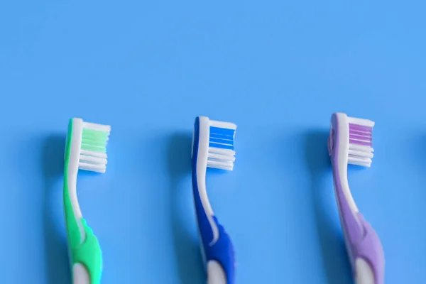 Toothbrushes on blue background. Flat lay composition with manual toothbrushes on color background, close up. copy space. vertical photo.