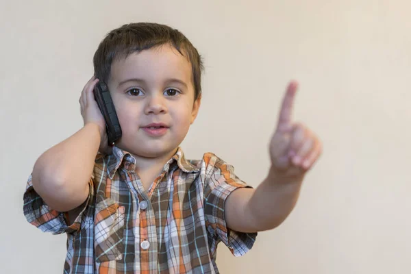 Ładny Mały Chłopiec Rozmawia Przez Telefon Komórkowy Jasnym Tle Szczęśliwy — Zdjęcie stockowe