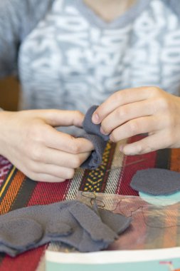 oluşturma. küçük kız keçe yapılan oyuncak diker. Küçük kız gri bir fare diker. Küçük kız bir oyuncak diker. dikey fotoğraf.