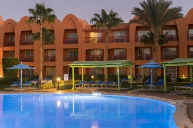 zarif tropikal havuzu ve veranda geceleri. Tropikal yüzme havuzunda gece görünümü - tatil arka plan. Alacakaranlıkta resort Yüzme Havuzu.