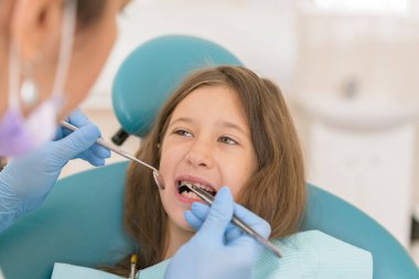 Açık ağız, diş hekimi ile genç çocuğun makro yakın çekim. Diş check-up dişçi ofisinde. Dişçi kız diş diş hekimleri sandalyede incelenmesi.