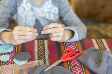 Bir iğne ve iplik ile küçük kız. oluşturma. küçük kız keçe yapılan oyuncak diker. oluşturma. küçük kız keçe yapılan oyuncak diker. Küçük kız gri bir fare diker. Küçük kız bir oyuncak diker.