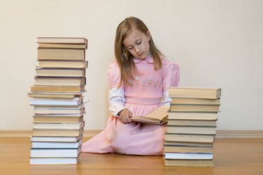 Bir dairede yerde oturan bir kitap okuyan kız. Sevimli kız evde kitap okuyor. eğitim ve okul kavramı - küçük öğrenci kız katta oturan ve kitap okuma.