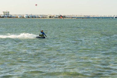Kitesurfing Kiteboarding eylem fotoğraflar adam dalgalar arasında hızlı bir şekilde gider. Bir uçurtma sörfçü dalgaları sürmek. lens aydınlatma. tonda.