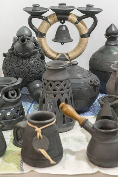 Clay dishes. Ceramic national Ukrainian dishes made in the Poltava region in the village of Opishnya and demonstrated at the in Velyki Sorochyntsi Fair. Burnt black ceramics. Burned clay jars.