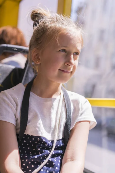 Mała dziewczynka idzie autobusem. Uczennica siedzi w szkole autobus i gotowy do jej pierwszej jazdy. Zdjęcie pionowe — Zdjęcie stockowe
