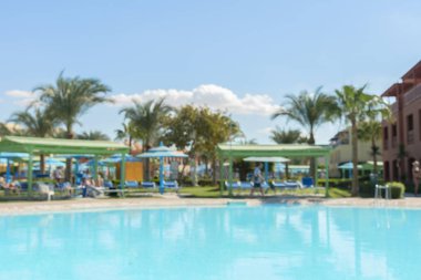 Havuz mavi serin gökyüzü ve tropikal palmiye ağacı ile yaz arka plan bulanıklık. Yaz bulanıklık arka plan havuz partisinde tropikal resort otel Yüzme Havuzu tatil tatil dinlenme yer