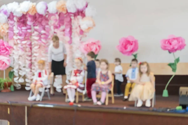 Детская вечеринка в начальной школе. Маленькие дети на сцене в детском саду выступают перед родителями. размытость — стоковое фото