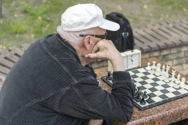 Szachista w parku. Stary człowiek gra w szachy w parku — Zdjęcie stockowe