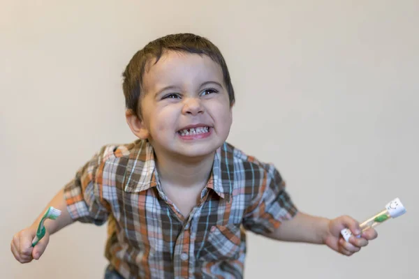 Retrato de un hermoso chico rubio caucásico lindo con un cepillo de dientes. Niño pequeño cepillándose los dientes y sonriendo mientras cuida la higiene bucal. Reloj de limpieza de dientes — Foto de Stock