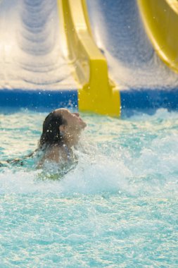 Güzel kız bir su kaydırağı sürme. mutlu kadın kauçuk halka turuncu slayt aqua Park tarafından aşağı gidiyor. Yaz tatili. Hafta sonu resort. dikey fotoğraf