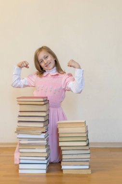 Kavram bilginin gücü. Bir sürü kitabı olan bir kız gücünü gösteriyor. Eğitim konsepti. alanı kopyalayın. dikey fotoğraf