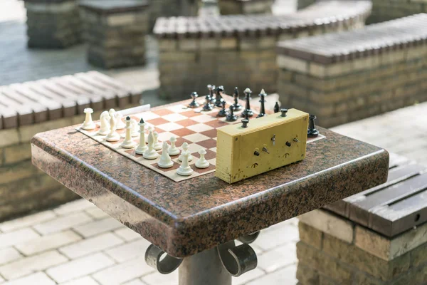 Schachbrett mit Figuren und Uhr auf Holztisch in Verbindung mit dem Schachturnier. Schachturnier mit Schachuhr auf Holztisch — Stockfoto