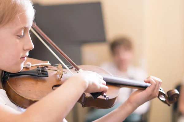 Criança, menina a tocar violino dentro de casa na aula de música. espaço de cópia — Fotografia de Stock