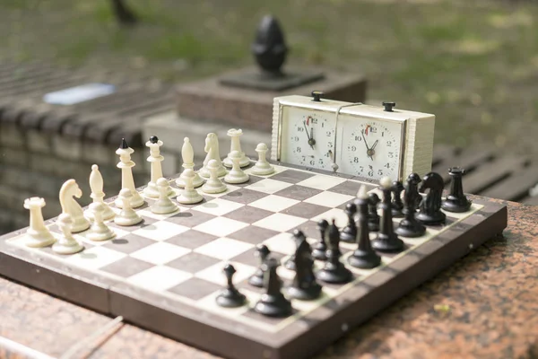 Schack bräde med lappar och klocka på trä skriv bord i anslutning med schackturneringen. Schackturnering med schack tar tid på trä bordlägger — Stockfoto