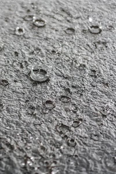 Rain gray background. Drops on a puddle. Vertical photo — Stock Photo, Image