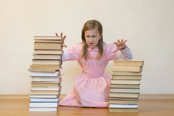 La colegiala está enfadada con los libros. El concepto de odio para estudiar y libros. La falta de voluntad de un niño para aprender . —  Fotos de Stock