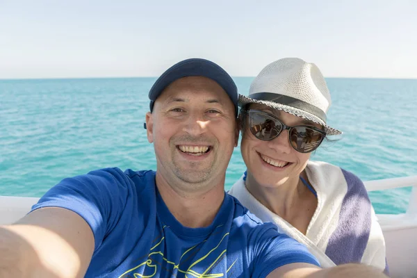 Feliz pareja de mediana edad tomando selfie en yate. Hermosa pareja feliz tomando selfie en la cubierta del yate flotando en el mar. Vela, tecnología, turismo, viajes y concepto de personas, haciendo vlog, vlog concepto — Foto de Stock