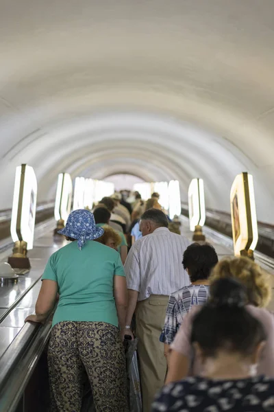 Pessoas no metro na escada rolante. Uma multidão de pessoas nas escadas do metro. foto vertical — Fotografia de Stock