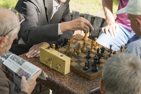 Personas jubiladas activas, viejos amigos y tiempo libre, personas mayores divirtiéndose y jugando al ajedrez en el parque. Cintura para arriba. Viejos jugando ajedrez en el parque — Foto de Stock