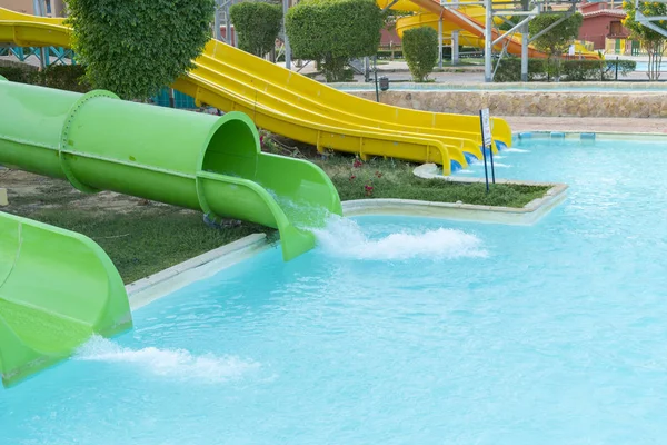 Färgglada plast diabilder i aquapark i solnedgången. reglagen, vattenpark — Stockfoto