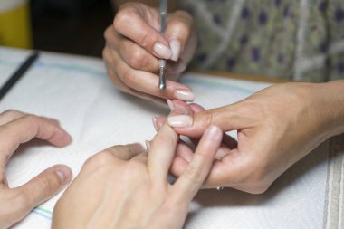 Tırnak dükkanında manikür işlemi sırasında kadın elini kapatın. Güzel konsept. kadın çivi manikür işleme