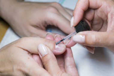 Güzellik salonunda manikür bıçak ile manikür tedavisi kadın el. salonda akrilik çivi bir fırça uygulama