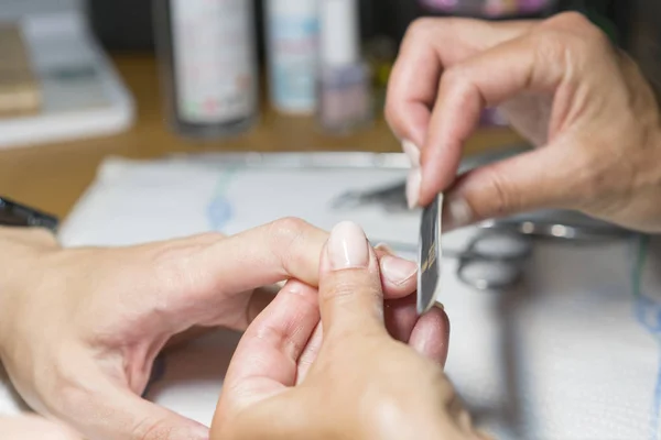 Proces manicure w salonie piękności, zbliżenie. kobiece manicure paznokci przetwarzania — Zdjęcie stockowe