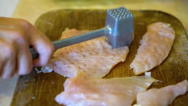 キッチンハンマーを使ってチキンシュニッツェルを作る女性のクローズアップ — ストック動画