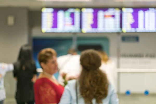 Turyści stoją przed informacjami zarządu we wnętrzu lotniska. Rozmycie obrazu osób oczekujących na lotnisku w hali przylotów i odlotów. Rozmazane — Zdjęcie stockowe