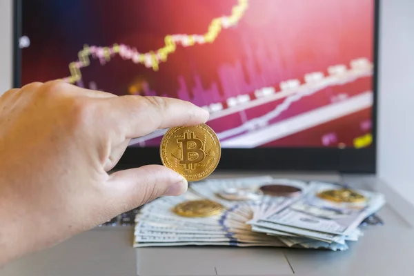 Bitcoin prijsverhoging grafiek. Bitcoins groei grafiek. Bitcoins en nieuw virtueel geld concept. Groei bitcoins. Dollar rekeningen op een laptop met bitcoin grafieken op een onscherpe achtergrond — Stockfoto