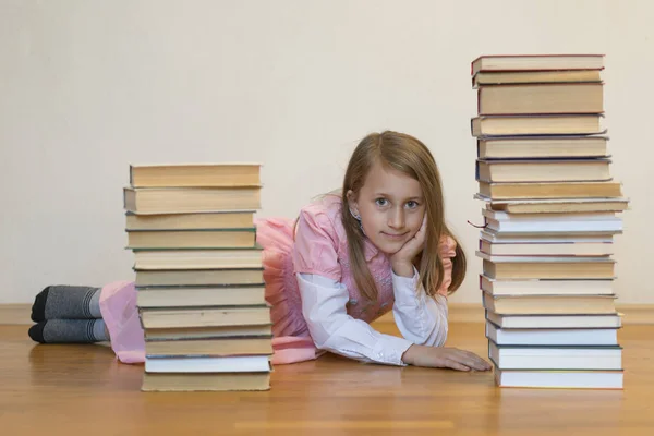 Gelukkig schoolmeisje met boeken in de kamer. Onderwijsconcept. terug naar school. Meisje in een roze jurk met boeken — Stockfoto