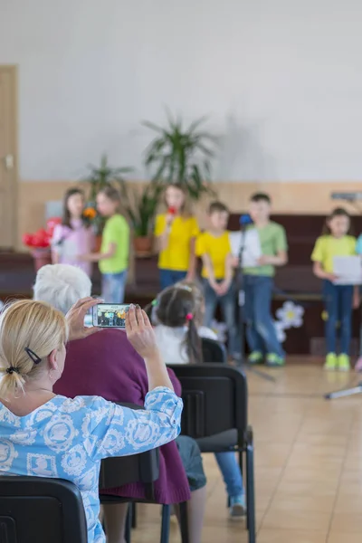 Prestazioni di bambini di talento. I bambini sul palco si esibiscono davanti ai genitori. immagine dello spettacolo del ragazzo sfocato sul palco a scuola, per l'uso in background. foto verticale. Sfocato — Foto Stock