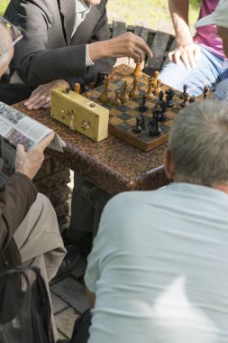 Aktif emekli insanlar, eski arkadaşlar ve boş zaman, yaşlılar eğlenmek ve parkta satranç oyunu oynarken. Bel yukarı. Parkta satranç oynayan yaşlı adamlar. dikey fotoğraf