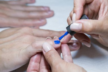 Güzel manikür süreci. El lerine uygulanan oje, cila mavi bir renktir. yakın çekim