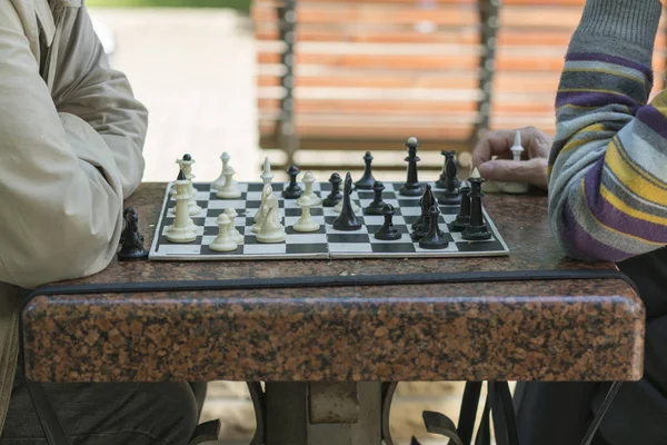 Active retired people, old friends and free time, two seniors having fun and playing chess game at park.